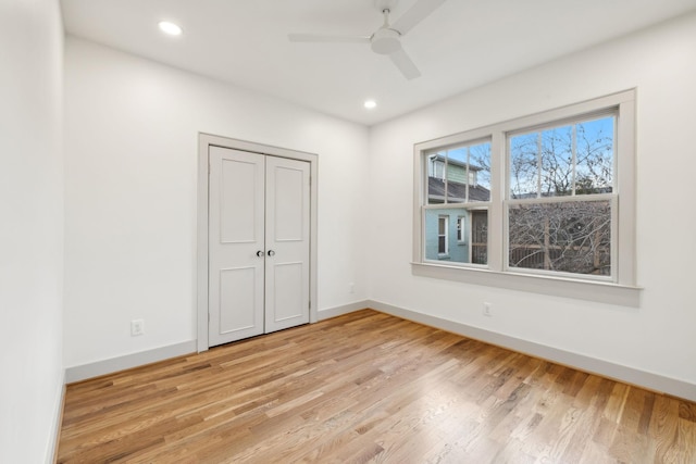 unfurnished bedroom featuring ceiling fan, light wood-type flooring, and a closet