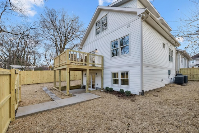 back of property with cooling unit, a wooden deck, and french doors