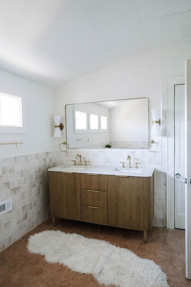 bathroom with tile patterned flooring, vanity, and tile walls