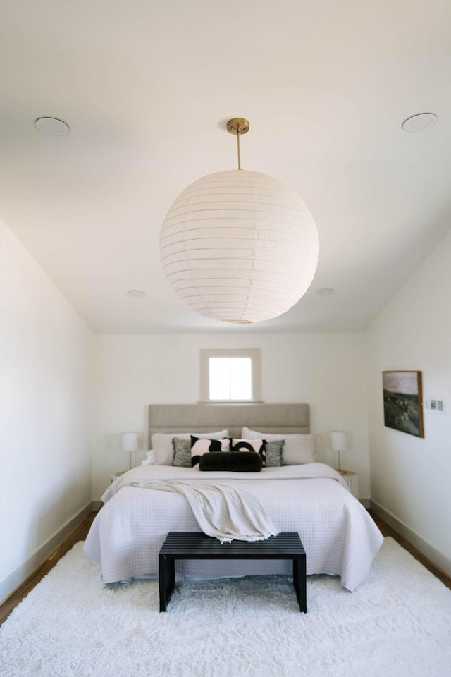 bedroom with hardwood / wood-style flooring and lofted ceiling