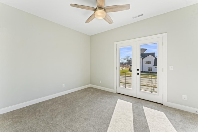 spare room with french doors, light colored carpet, and ceiling fan