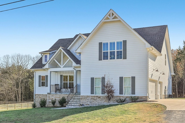 view of front of house featuring a front lawn, covered porch, and a garage