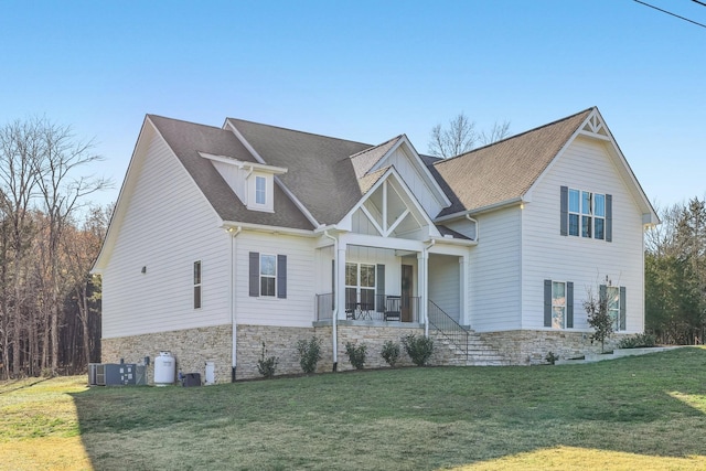 view of front of property with a porch, central AC, and a front lawn