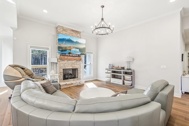 living room with a chandelier, a fireplace, light hardwood / wood-style floors, and ornamental molding