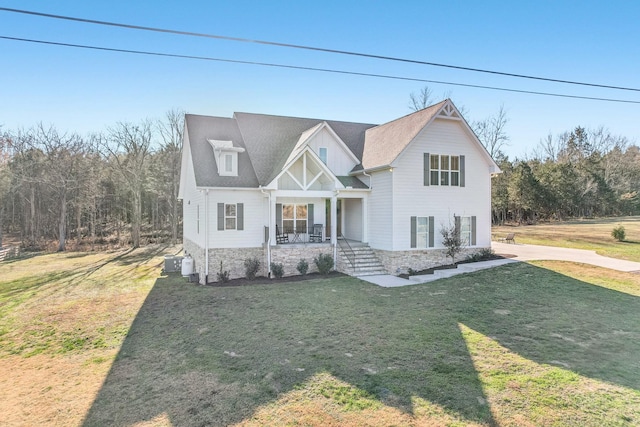 view of front of home with covered porch, central AC unit, and a front lawn