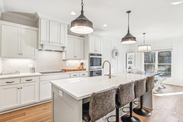 kitchen with decorative light fixtures and a kitchen island with sink