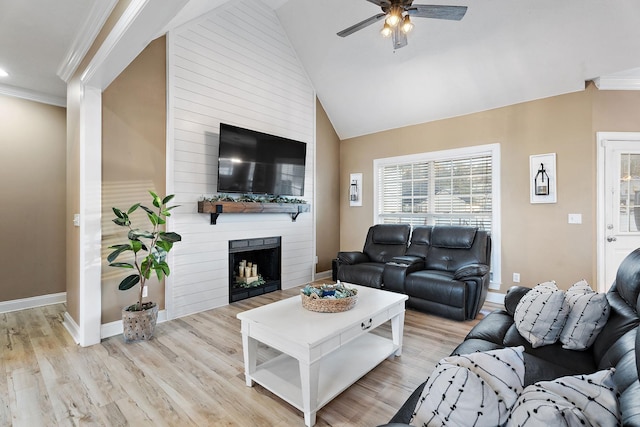 living room with light wood-type flooring, a fireplace, high vaulted ceiling, and ornamental molding