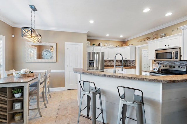 kitchen with decorative backsplash, crown molding, white cabinetry, and stainless steel appliances