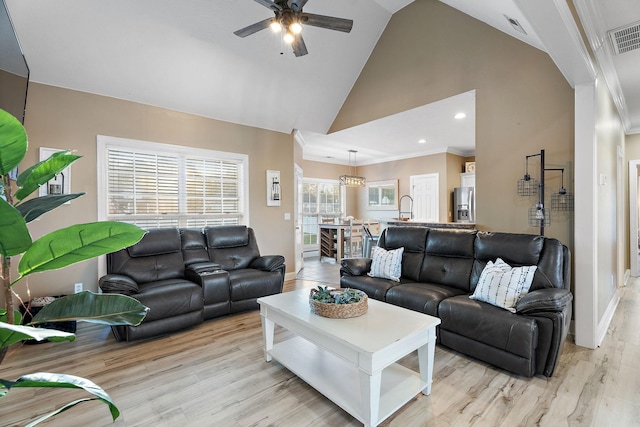 living room featuring light hardwood / wood-style flooring, high vaulted ceiling, ceiling fan, and ornamental molding