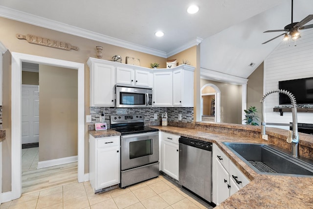 kitchen featuring white cabinetry, sink, vaulted ceiling, appliances with stainless steel finishes, and ornamental molding