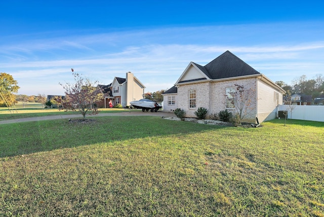 view of side of home with a yard