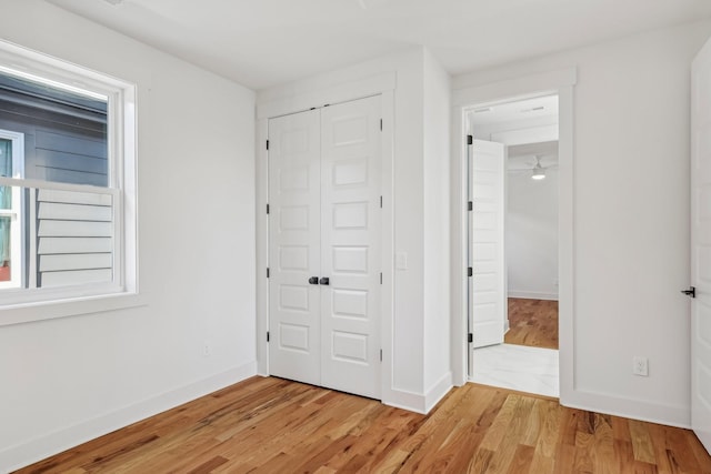 unfurnished bedroom featuring light wood-type flooring and a closet