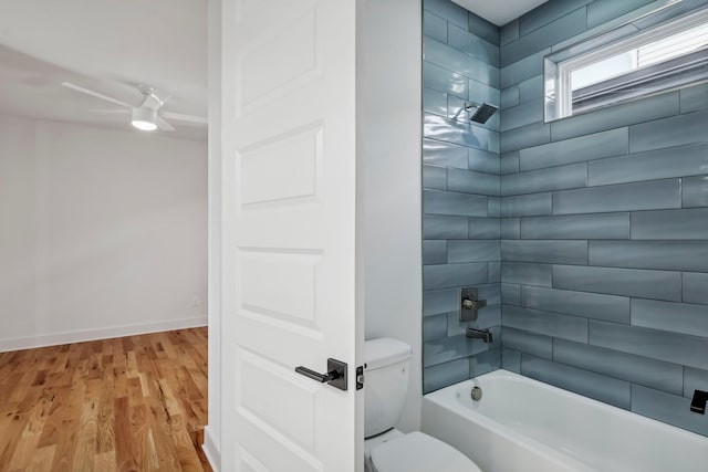 bathroom with wood-type flooring, tiled shower / bath combo, toilet, and ceiling fan