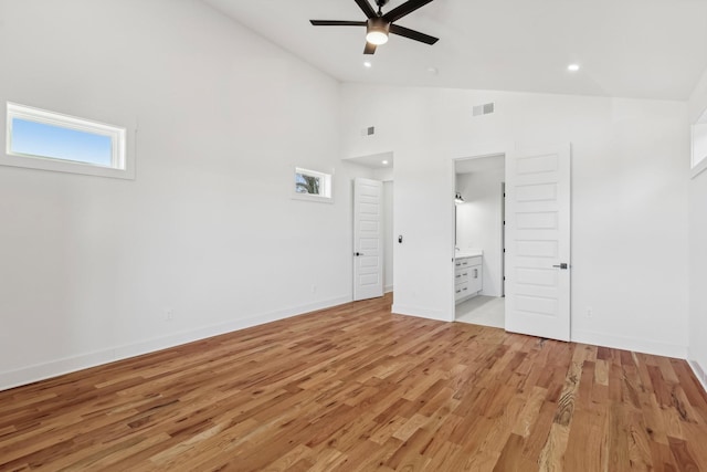 unfurnished bedroom featuring ensuite bath, ceiling fan, high vaulted ceiling, and light hardwood / wood-style floors