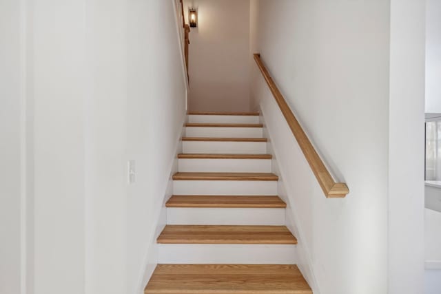 stairs featuring hardwood / wood-style floors