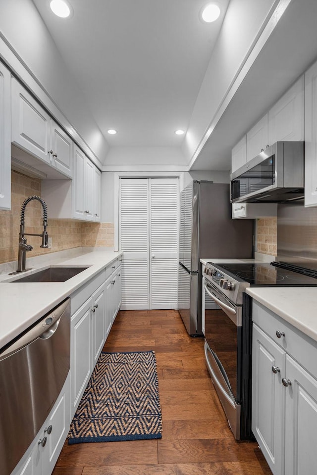 kitchen featuring sink, white cabinetry, stainless steel appliances, and dark wood-type flooring