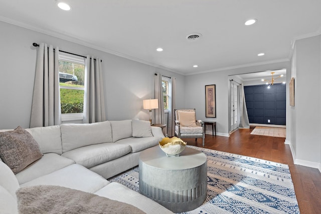 living room with an inviting chandelier, crown molding, and dark wood-type flooring