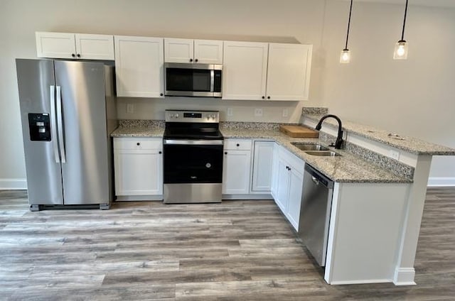 kitchen featuring white cabinets, stainless steel appliances, kitchen peninsula, and sink