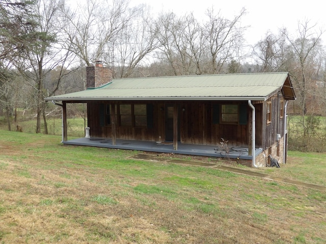 view of outdoor structure with a lawn and a porch