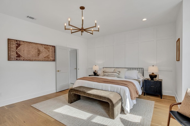 bedroom with a chandelier and light hardwood / wood-style floors