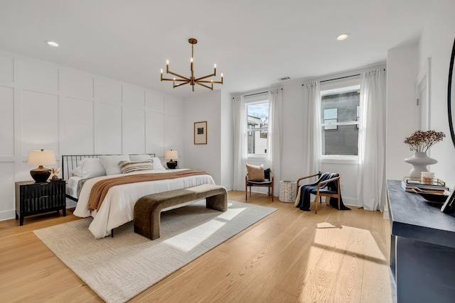 bedroom featuring light hardwood / wood-style floors and a notable chandelier