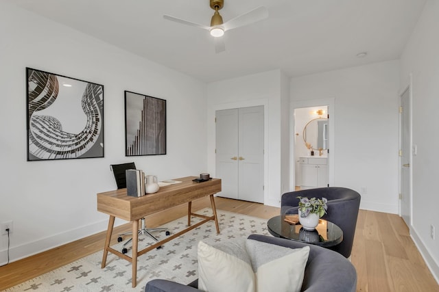 home office with ceiling fan and light hardwood / wood-style flooring