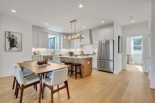 dining space with light wood-type flooring and sink