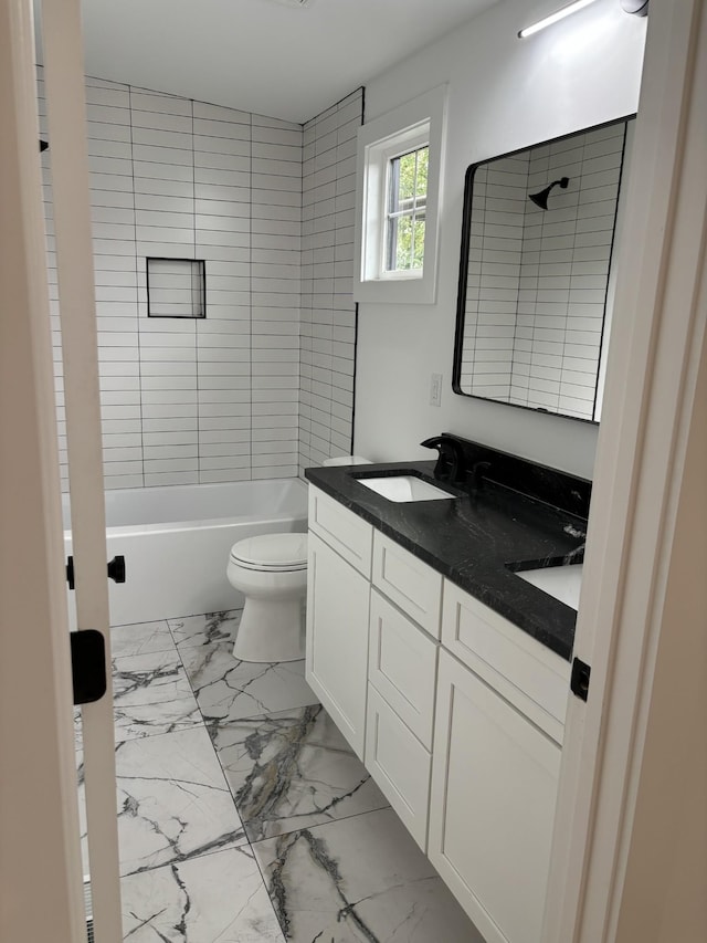 full bathroom featuring vanity, toilet, and tiled shower / bath