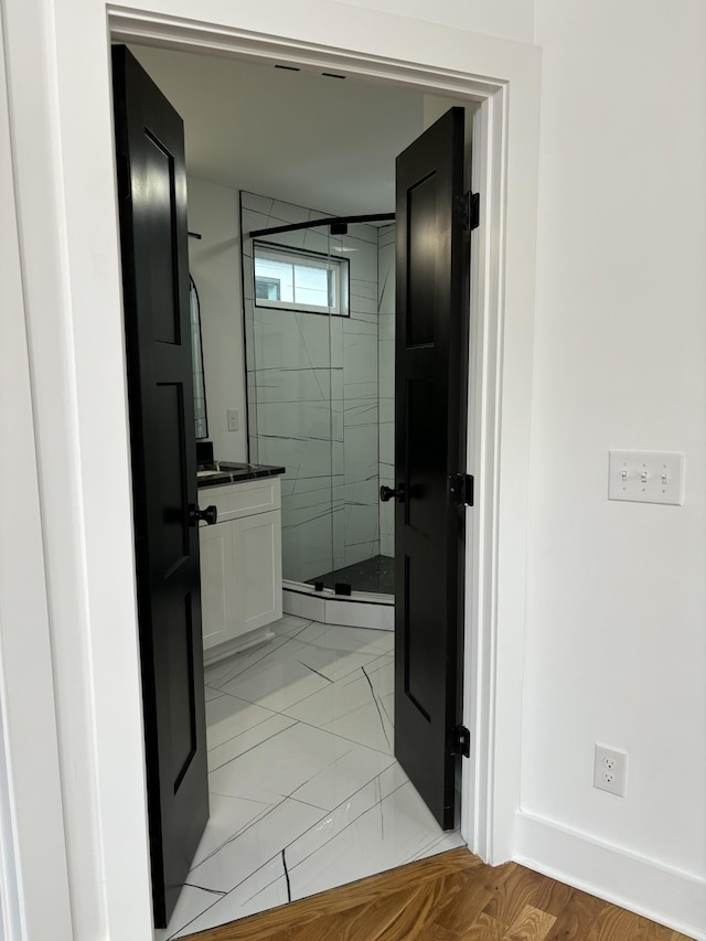 bathroom with tile patterned flooring, vanity, and walk in shower