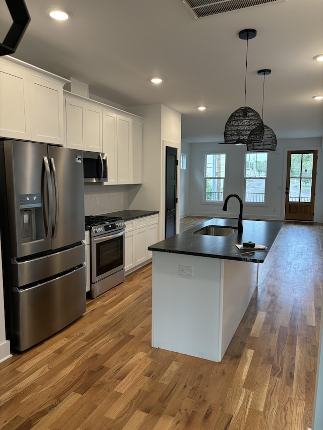 kitchen featuring plenty of natural light, white cabinetry, sink, and appliances with stainless steel finishes