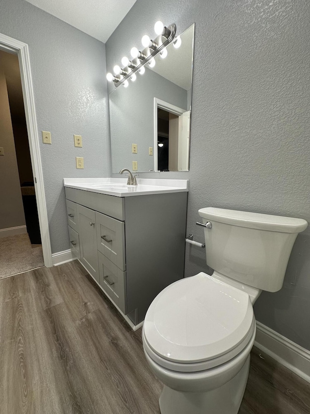 bathroom featuring hardwood / wood-style flooring, vanity, and toilet