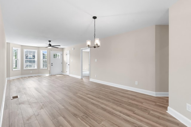 unfurnished living room featuring light hardwood / wood-style floors and ceiling fan with notable chandelier