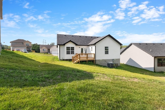 rear view of property featuring cooling unit, a yard, and a wooden deck