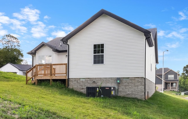 back of house with a yard, a deck, and central AC unit