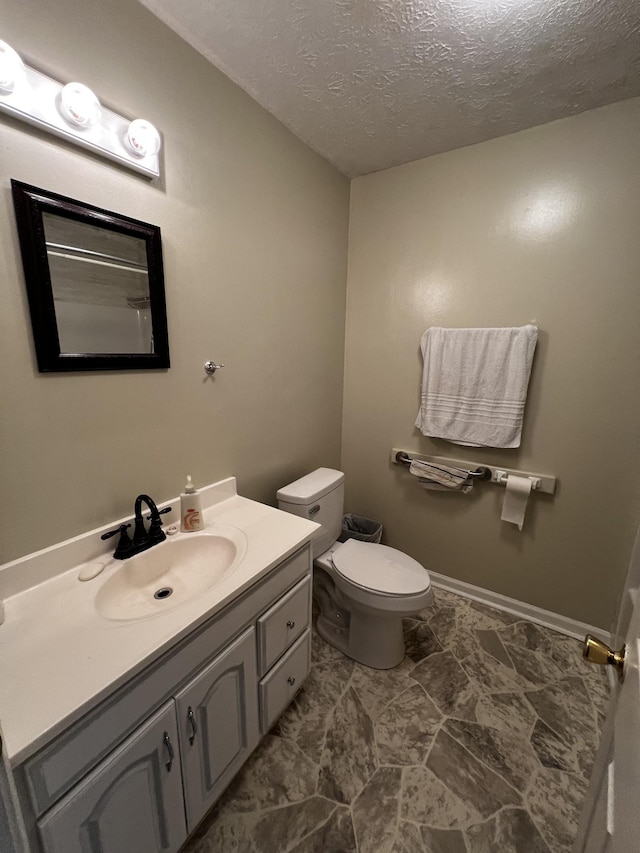 bathroom with vanity, a textured ceiling, and toilet