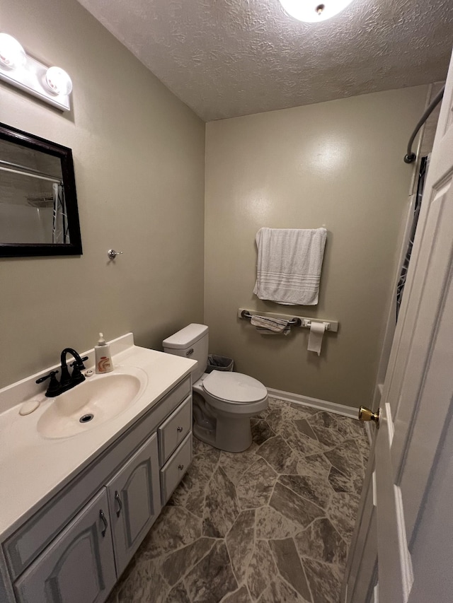 bathroom with vanity, a shower, a textured ceiling, and toilet