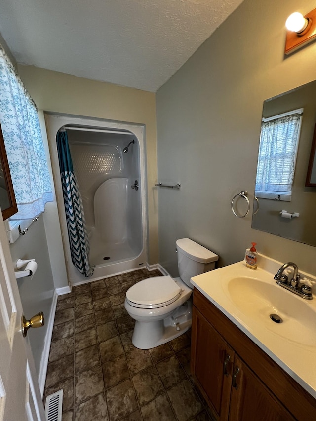 bathroom featuring curtained shower, vanity, a textured ceiling, and toilet