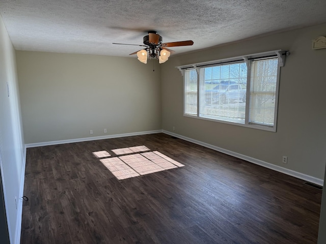 empty room with ceiling fan, dark hardwood / wood-style flooring, and a textured ceiling