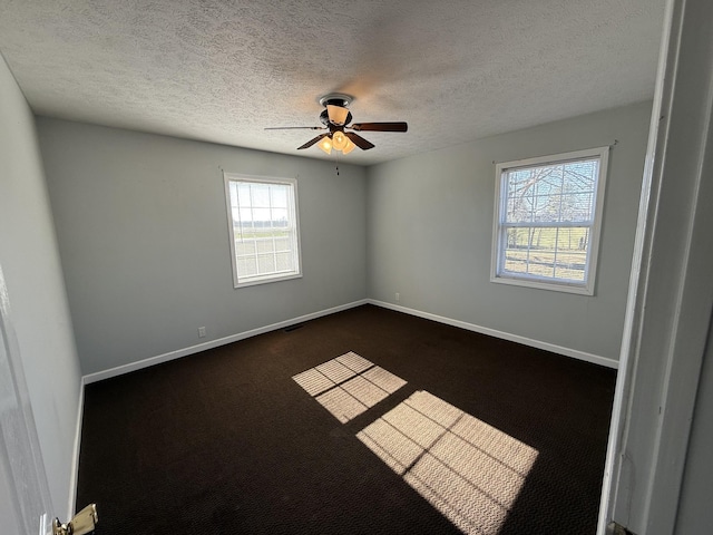 empty room featuring plenty of natural light, ceiling fan, and a textured ceiling