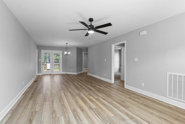 unfurnished living room featuring light hardwood / wood-style floors and ceiling fan with notable chandelier