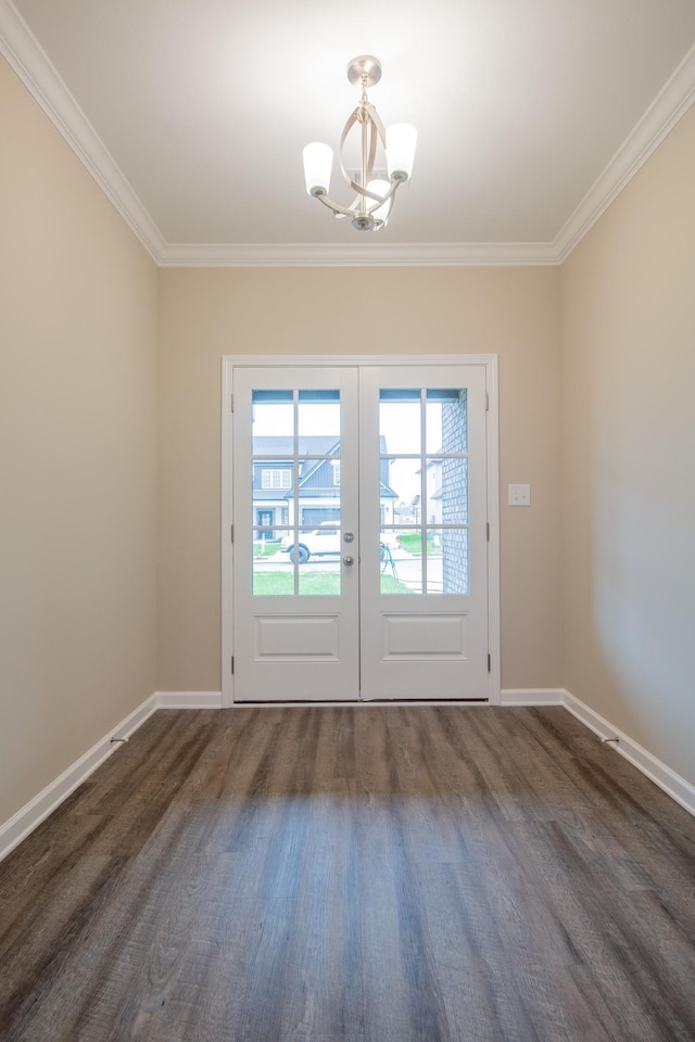 entryway featuring crown molding, french doors, dark wood-type flooring, and an inviting chandelier