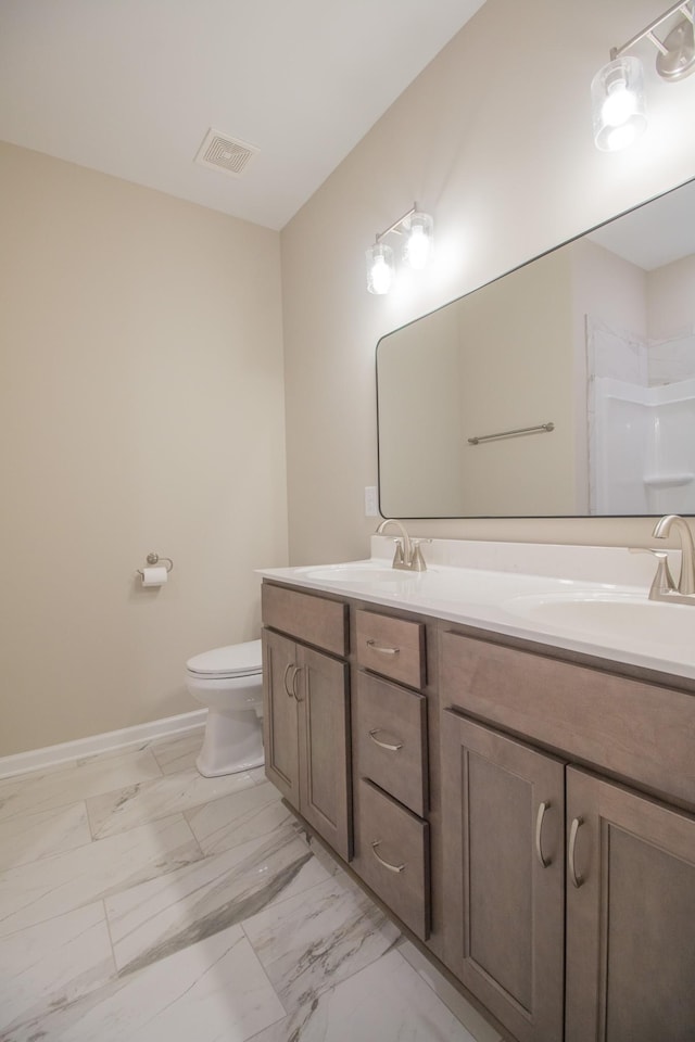 bathroom featuring vanity, toilet, and a shower with shower door