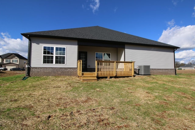 back of house featuring a deck, central AC unit, and a lawn