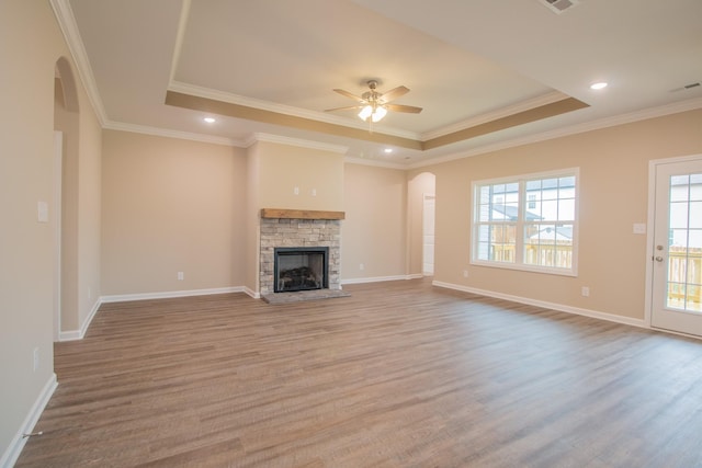 unfurnished living room featuring light hardwood / wood-style floors, a raised ceiling, ceiling fan, and crown molding