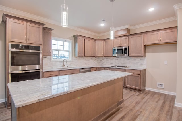 kitchen featuring light stone countertops, sink, light hardwood / wood-style floors, decorative light fixtures, and appliances with stainless steel finishes