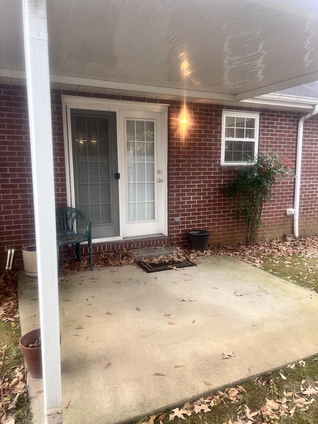 view of exterior entry with a patio