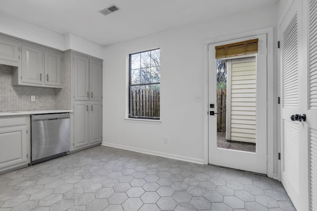 kitchen featuring backsplash, stainless steel dishwasher, and light tile patterned flooring