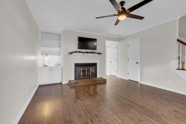 unfurnished living room featuring ceiling fan, dark hardwood / wood-style flooring, crown molding, and built in shelves