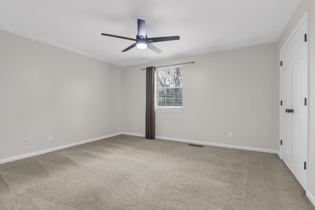 empty room with carpet, ceiling fan, and ornamental molding