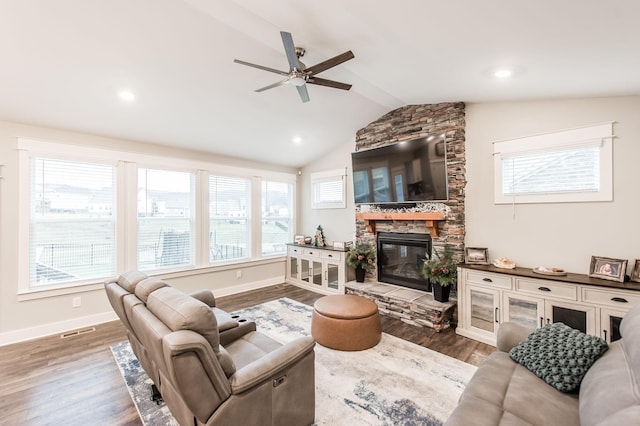 living room featuring a stone fireplace, a wealth of natural light, and hardwood / wood-style floors